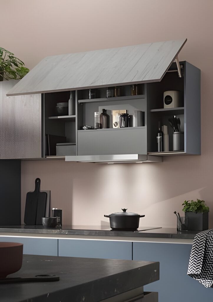 verhead cabinet, displaying various kitchen items including utensils and containers. A pot is on the stove, and a small plant is on the counter. The space features an integrate lift system for effortless access to stored items.