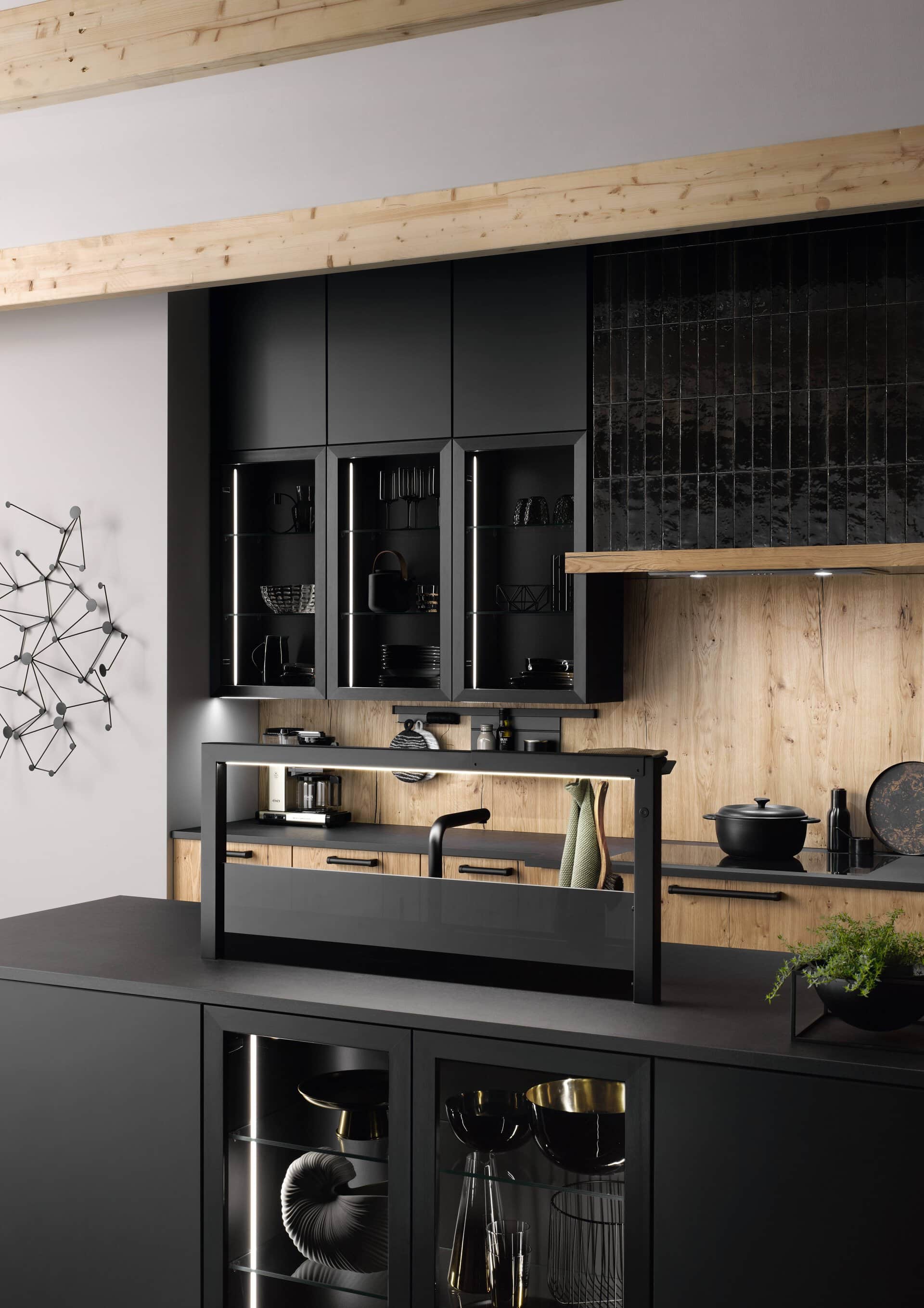 A modern kitchen with black cabinet design and wooden accents.